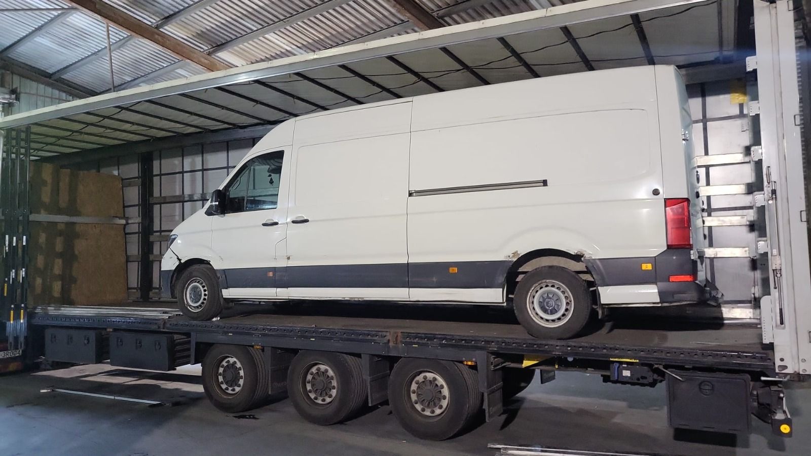 Samochód dostawczy zabezpieczony na naczepie Express Trucks w hali